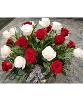 12 red and 12 white roses arranged in a vase with  Greens