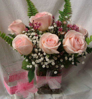 6 Pink Roses in a cute ribbon detail vase with baby's breath and wax flowers.