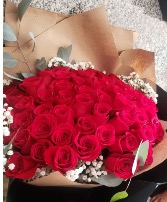 60 red roses wrapped  brown paper 