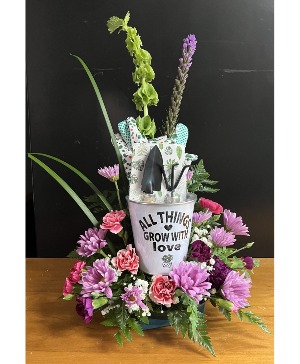 Bucket of gardening tools fresh flowers with keepsake