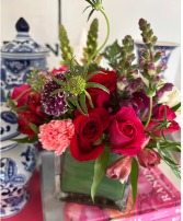 Cube with red roses, carnations and snaps. 