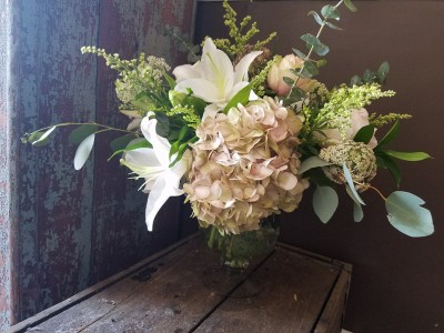 delicate pastel arrangement Oriental lillies, soft pink hydrangea, naked eucalyptus, queen Ann's Lace, soft pink rose, cream solidago, and baby blue Eucalyptus