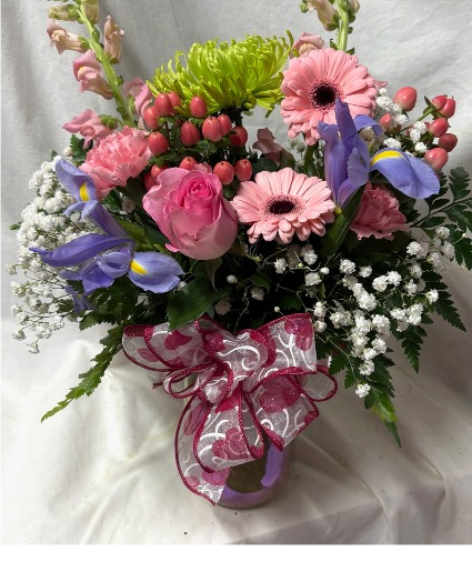 Delightfully Pink...pink, blue and green flowers arranged in a Purple , pink qt mason jar...whatever color is in stock