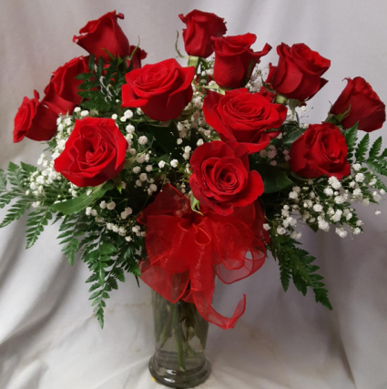 Dozen Red Roses arranged in a vase with  baby's breath and ribbon!