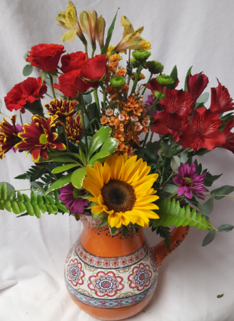 FIESTA PITCHER arranged with bright seasonal Flowers. (Pitchers may vary in color) Great keepsake container!!!