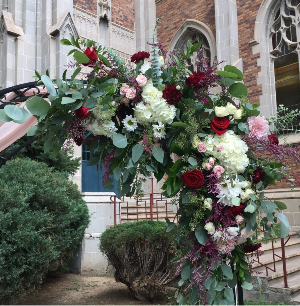 Garden Romance Bold red roses and lush greenery come together for a show-stopping arch that sets the stage for your unforgettable moment