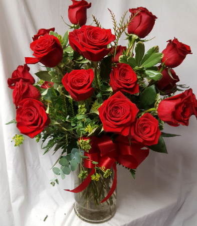 24 Red Roses arranged in a Vase with seasonal Greens and bow!