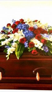 PASSIONATE GRACE Half Casket Spray of seasonal Reds, whites and Blues. Roses, delphinium,  hydrangea and more.