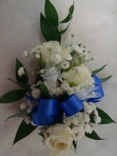 Most Popular wrist corsage with 3 sweetheart  roses and includes real greens and baby's breath. Call to let us know what ribbon you would like