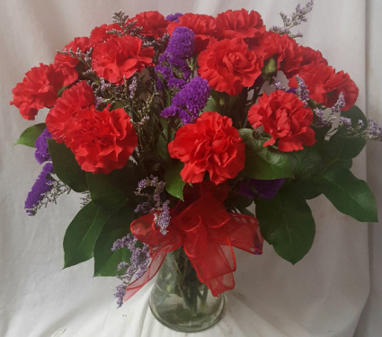 DOZEN RED CARNATIONS WITH PURPLE STATUS ARRANGED in a vase!