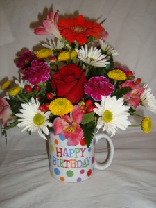 Happy Birthday mug with bright flowers arranged  in it!! 