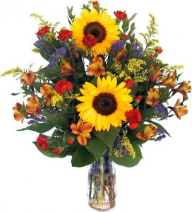 THOUGHTS AND PRAYERS TRIBUTE Mixed seasonal flowers in a vase.
