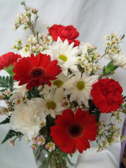 Miami colors! Red and white flowers arranged in a  v a se.