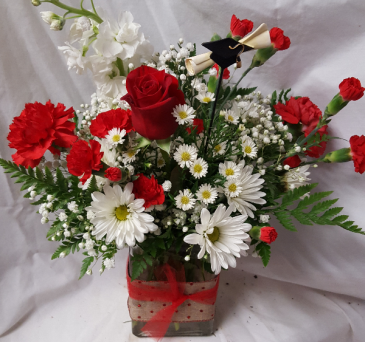 Miami congratulation arrangement a pic that has a hat and diploma. This Arrangement will have different Reds and white flowers.