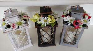 Lantern 12" with LED Candle with removable silk Flower ring. Antique white,  Antique Gray, and Antique Brown. We will select what is available for you. Silk flowers may be different colors also. .If you want certain one...please call to see what is available.. 3 Triple A batteries not included. 