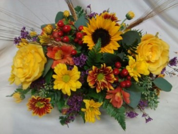 Thanksgiving centerpiece with roses and other fall bright seasonal flowers. Low and long arranged for your table.