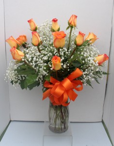 Orange long stemmed roses Arranged in glass vase