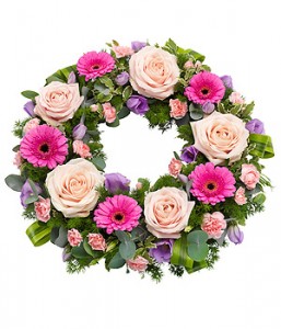 Pink shades of flowers in a round wreath. Roses,  gerbera minis, carnations with different greens
