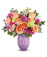 Peach & Plum Radiance Brighten her Mother’s Day with glowing beauty—roses, carnations, and more in a radiant purple glass vase.