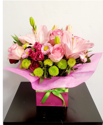 pink box flower arrangement in wood container