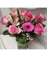 DELIGHTFULLY PINK..shades of pink flowers arranged In a rectangular vases with green detail.