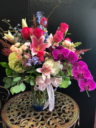 Premium floral mixed bouquet This arrangement has hydrangea, roses, lilies, orchids, and delphinium with silver dollar eucalyptus and spray roses.