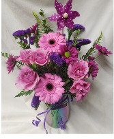 "PURPLE LOVERS" SHADES of purples, lavenders, Etc. (Flowers may vary depending on stock) arranged in a irresdescent mason jar quart size with purple pinwheel pic!