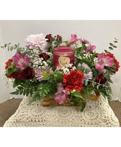 Romantic candle arrangement Fresh flowers in a basket