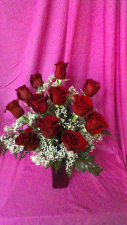 R12SS Sent With Love dozen short stemmed roses and baby breath arranged in a red vase
