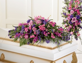 JOYFUL THOUGHTS Half Casket Spray of shades of Purples. Roses, iris, snapdragons, status and more