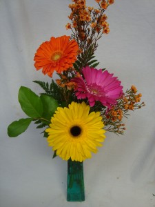 3 Bright Gerbera Daisies arranged in a tall colored vase with filler!! Very Popular!!