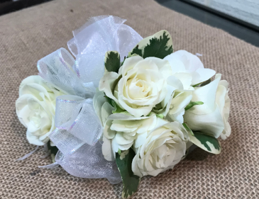 This classic prom wrist corsage of white baby roses and white ribbon