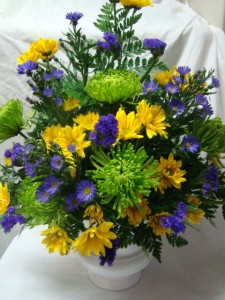 EXPRESSIONS OF SYMPATHY Flowers in shades of greens, blues, and yellows arranged