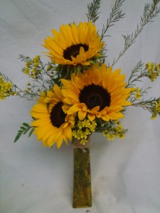 3 Large Sunflowers with filler in a tall vase! SEASONAL SO WE MAY NEED TO SUBSTITUTE YELLOW GERBERA DAISIIES, also vase may be clear if colored out of stock.