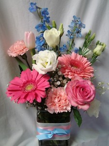 'WHITE AND BLUE COLORS WITH A WHITE ROSE FOR THE SORORITY FLOWER! ALL ARRANGED IN A CUTE RECTANGULAR VASE WITH PINK AND BLUE RIBBON DETAIL!