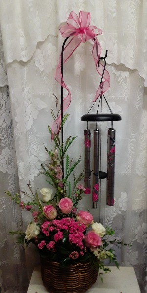 wind chimes in the garden Plant basket with fresh roses, wind chime