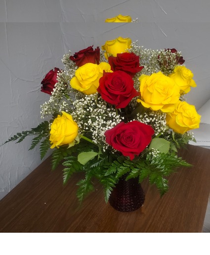 Yellow and red roses vased