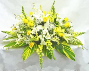 GOLDEN SUNSHINE Half Casket Spray of seasonal shades of yellows and whites. Roses, snap dragons, lillies and more.